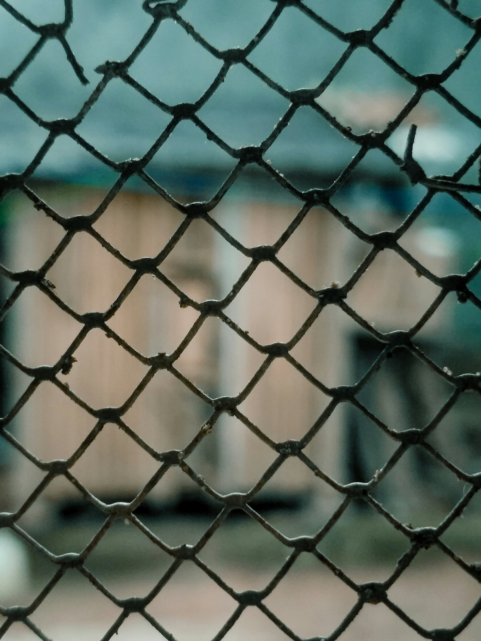 Close view of dark chain link mesh in front of a building