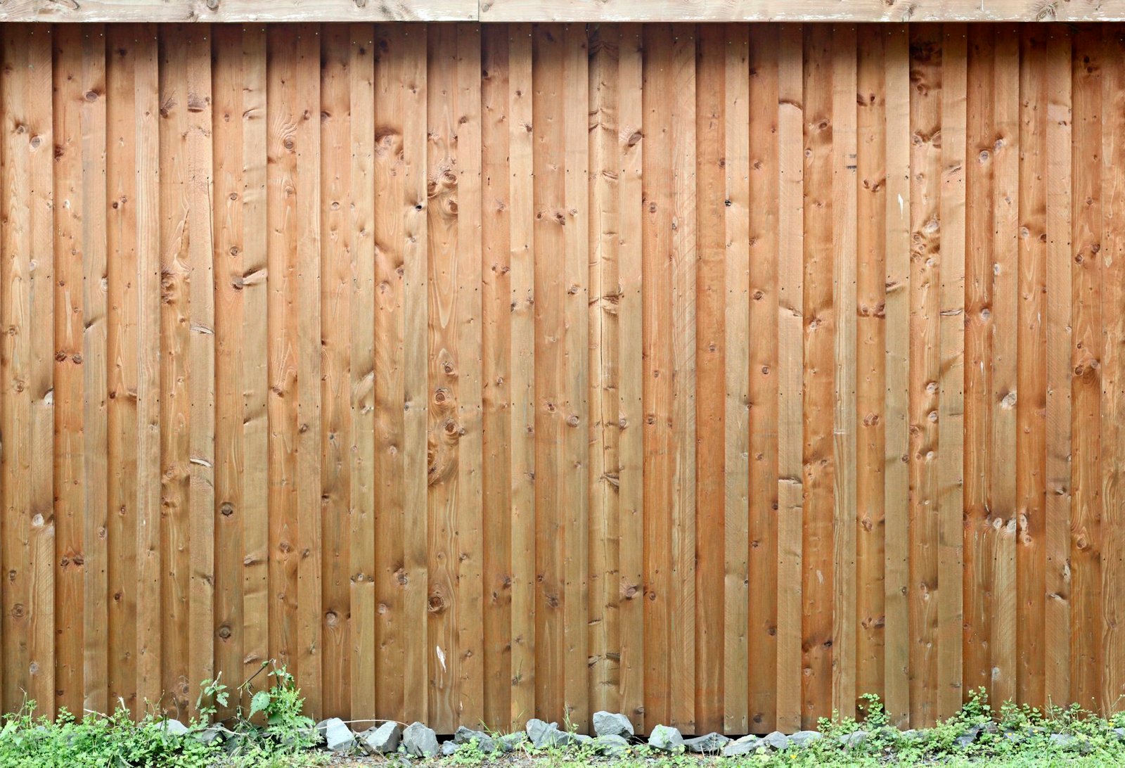 New close-board timber fence above a strip of gravel and planting